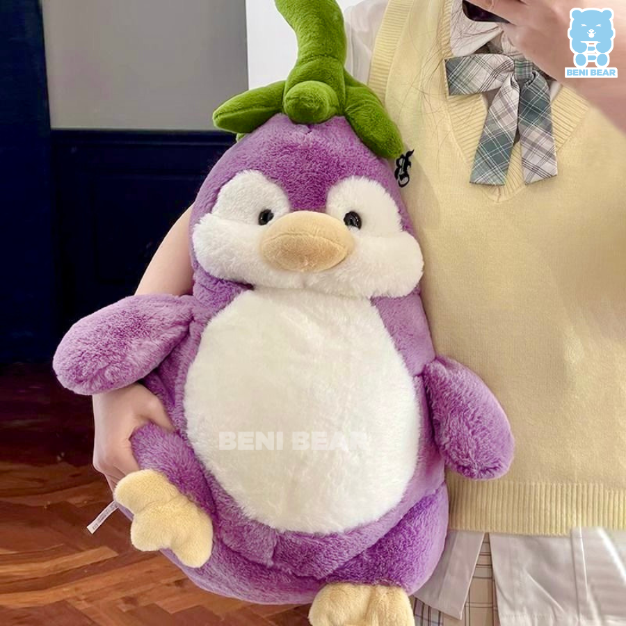 Gấu bông cánh cụt cà tím size lớn được ôm trên tay, thân tím tròn bụ bẫm, lá xanh cực đáng yêu