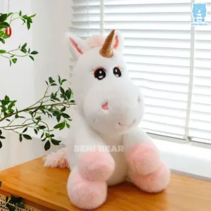 Gấu bông kỳ lân chibi mắt to tròn, chân hồng pastel ngồi cạnh cửa sổ, lông trắng mịn như mây