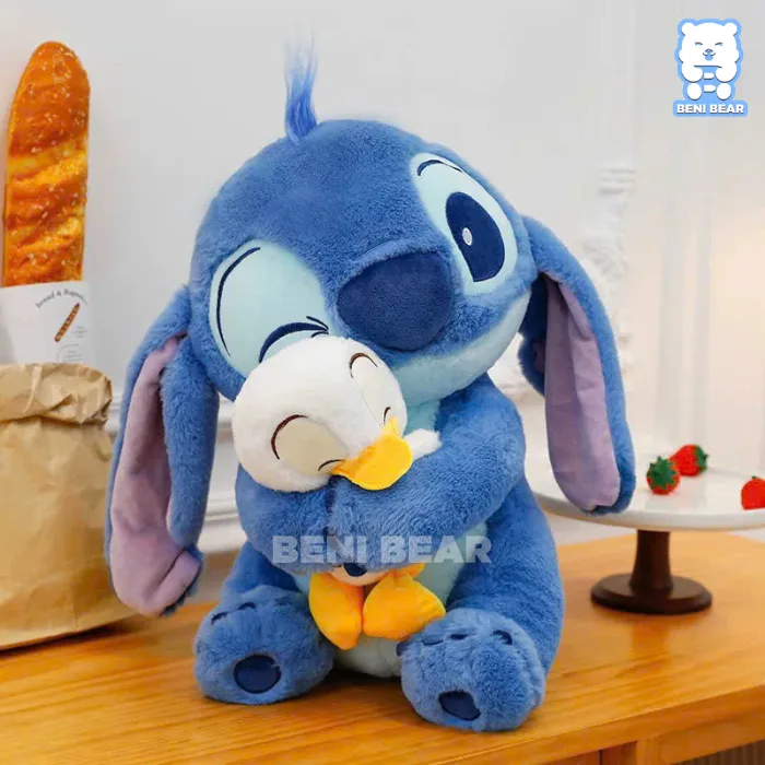 Gấu bông Stitch Xanh đang ôm vịt với vẻ mặt hiền lành và đáng yêu