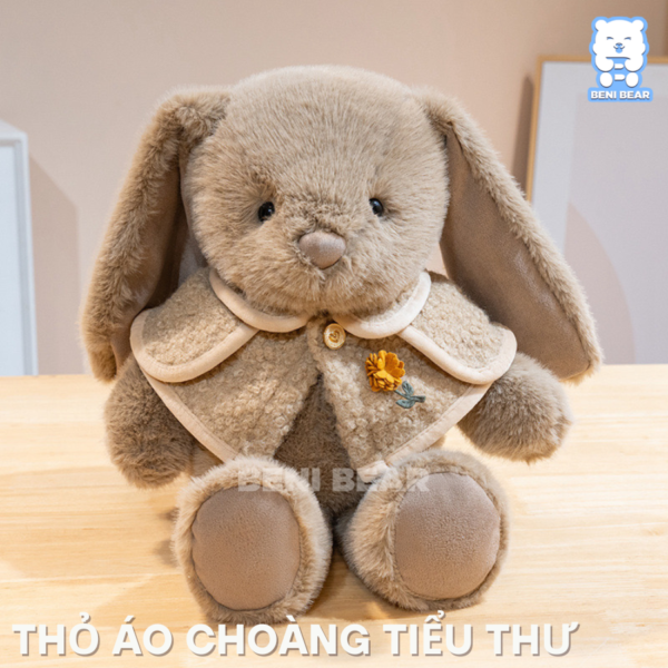 Gấu bông thỏ áo choàng màu nâu với tai dài đáng yêu và áo choàng lông mịn, hoa cài tinh tế