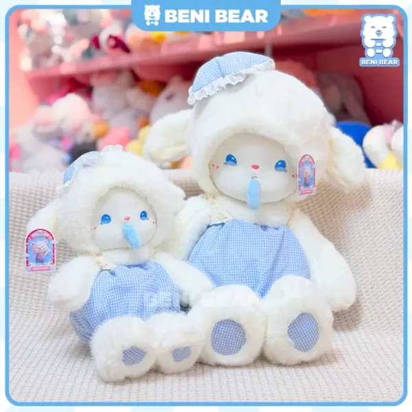 Cừu trắng mặc yếm xanh kẻ caro đang ngồi với kiểu dáng xinh xắn.